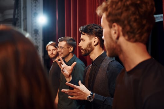 Working together. Group of actors in dark colored clothes on rehearsal in the theater photo
