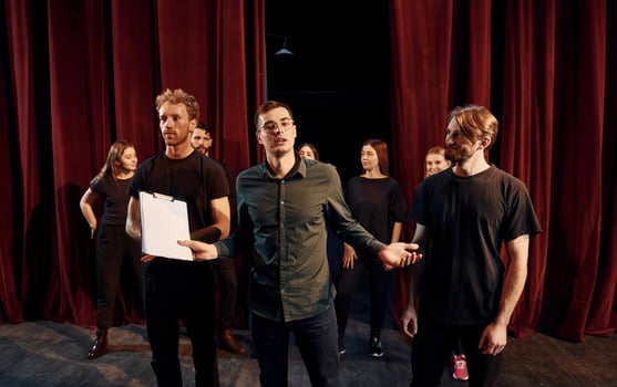 Working together. Group of actors in dark colored clothes on rehearsal in the theater photo