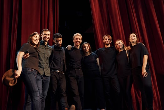 Working together. Group of actors in dark colored clothes on rehearsal in the theater photo