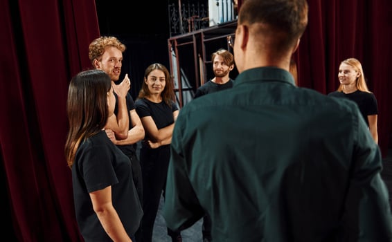 Working together. Group of actors in dark colored clothes on rehearsal in the theater photo