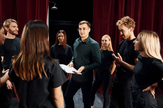 Group of actors in dark colored clothes on rehearsal in the theater photo