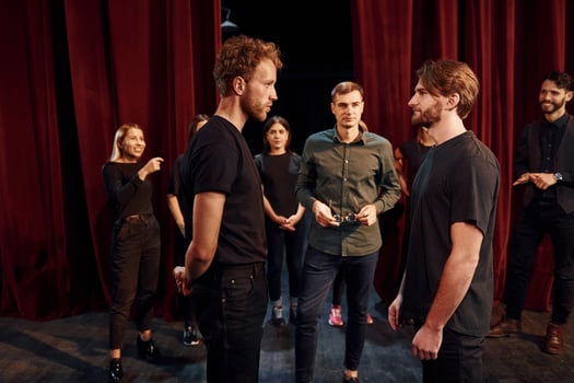 Eye contact practice. Group of actors in dark colored clothes on rehearsal in the theater photo