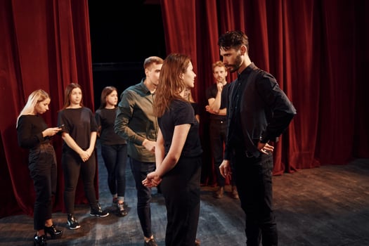 Eye contact practice. Group of actors in dark colored clothes on rehearsal in the theater photo