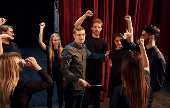 Practice in progress. Group of actors in dark colored clothes on rehearsal in the theater photo