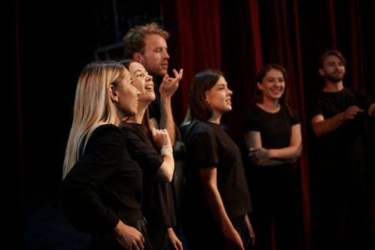 Side view. Group of actors in dark colored clothes on rehearsal in the theater photo
