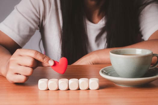 Hand holding wood cube hearts arranged in a row, mock up for create symbol or logo, business growth and management concept. photo