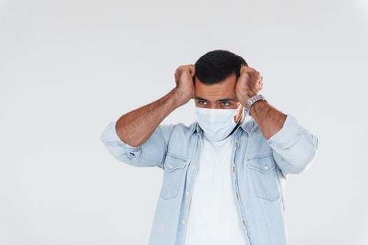 Headache and pain. Young handsome man standing indoors against white background photo