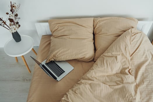 Laptop is on the bed. Interior and design of beautiful modern bedroom at daytime photo