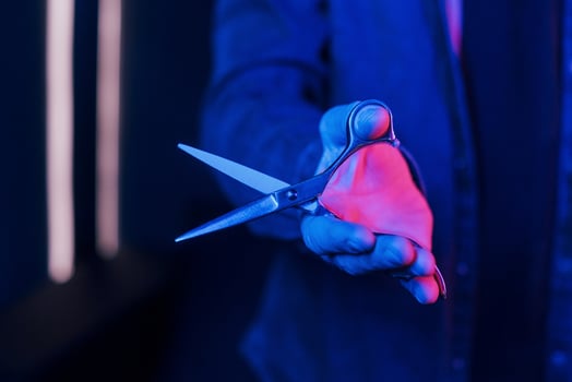 Close up view of barber's hands that holding scissors. Neon lighting photo