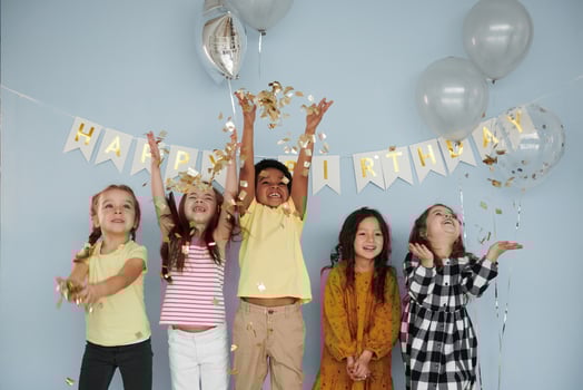 Balloons and confetti. Children on celebrating birthday party indoors have fun together photo