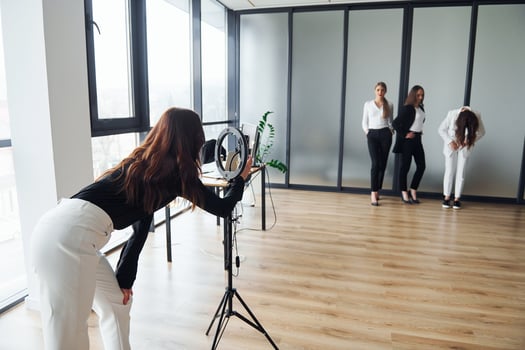 Backstage of photoshoot. Group of adult women that in formal clothes is indoors in the office together photo