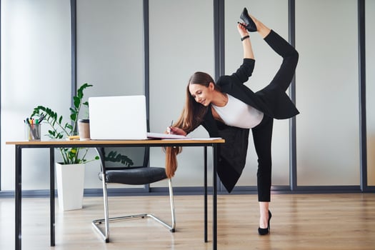 With laptop. Young adult woman in formal clothes is indoors in the office photo