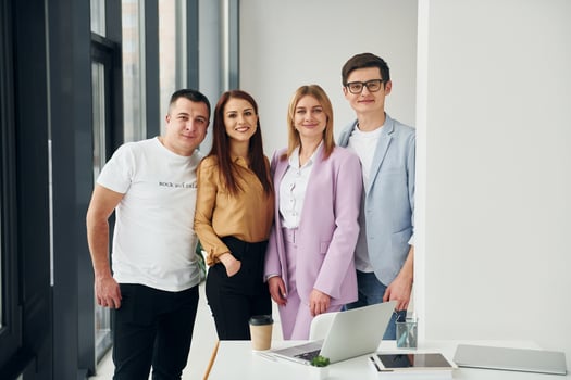 Standing together. Group of people in official formal clothes that is indoors in the office photo