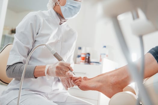 Woman lying down and have operation on her feet by professional clinic worker photo