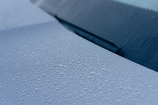 Raindrops on the hood of the car. Close-up. photo
