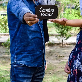 Indian couple posing for maternity baby shoot. The couple is posing in a lawn with green grass and the woman is falunting her baby bump in Lodhi Garden in New Delhi, India photo