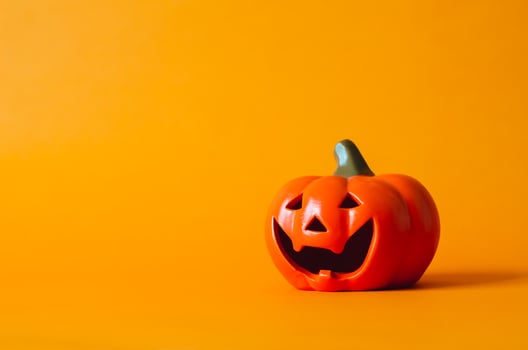 Halloween pumpkin on orange background. Halloween minimal concept. photo