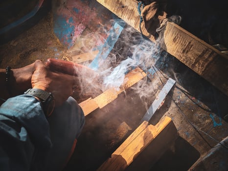 man drilling ironwood in a boat photo