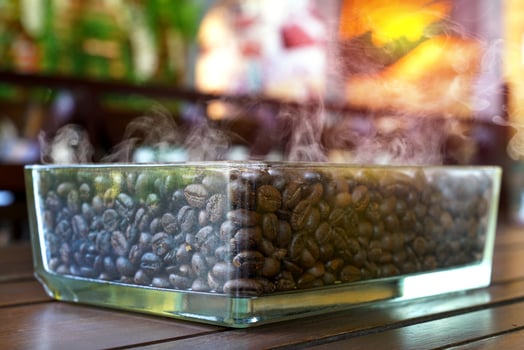 Roasted coffee beans in clear glass box with smoke photo