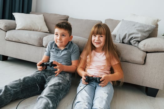 Playing videogames. Kids having fun in the domestic room at daytime together photo