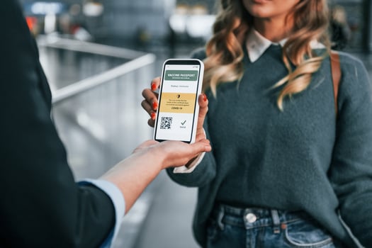 Vaccination certificate in the phone. Young female tourist is in the airport at daytime photo