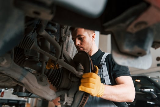 Professional service. Man in uniform is working in the auto service photo