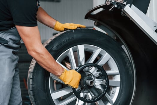 Taking the wheel. Man in uniform is working in the auto service photo