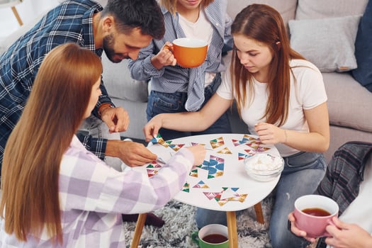 Playing puzzle game. Group of friends have party indoors together photo