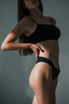 In dark room. Beautiful woman in underwear is posing indoors photo