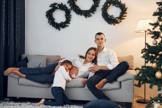 With Christmas tree. Happy family celebrating holidays indoors together photo