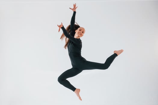 Professional exercises. Young woman in sportive clothes doing gymnastics indoors photo