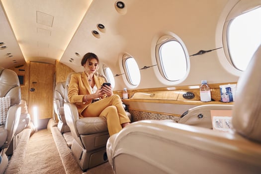 Woman in yellow clothes sits inside of private airplane photo