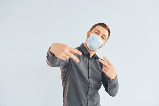 Man in grey shirt is posing indoors against white background photo
