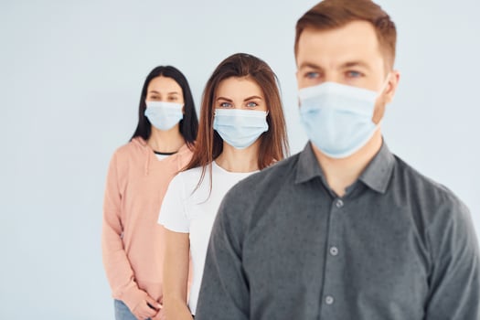 Two women and man standing together indoors in the studio against white wall photo