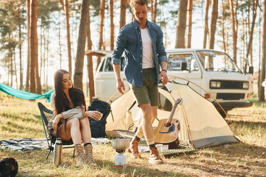 Having a rest. Young couple is traveling in the forest at daytime together photo