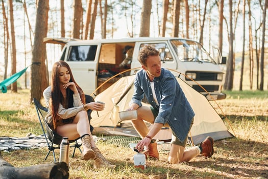 Having a rest. Young couple is traveling in the forest at daytime together photo