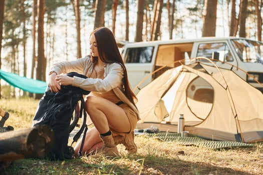In the camp. Woman is traveling alone in the forest at daytime at summer photo