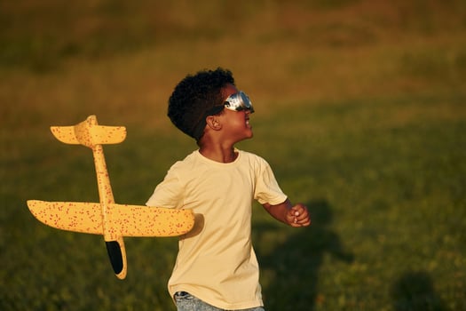 Weekend activities. African american kid have fun in the field at summer daytime photo
