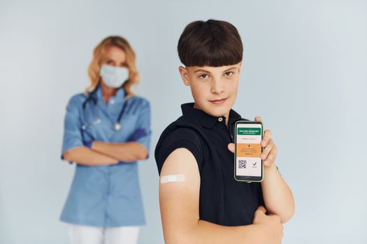 Young boy. Doctor in uniform making vaccination to the patient photo