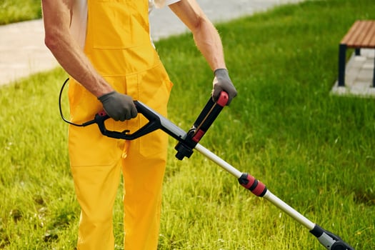 Close up view. Man cut the grass with lawn mover outdoors in the yard photo