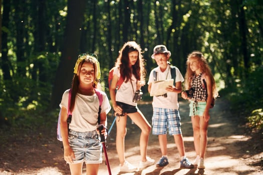 Ready for adventure. Kids strolling in the forest with travel equipment photo