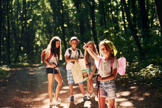 With touristic equipment. Kids strolling in the forest photo
