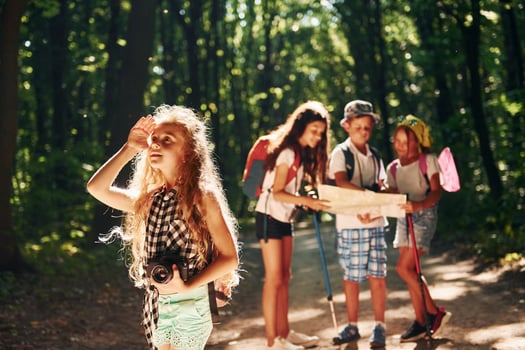 Girl looking far away. Kids strolling in the forest with travel equipment photo