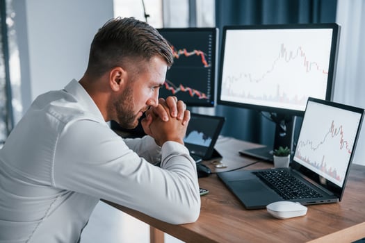 Focusing on the work. Young businessman in formal clothes is in office with multiple screens photo