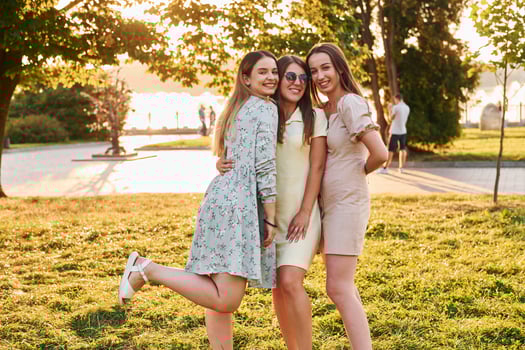 Three women standing in the autumn park together. Beautiful sunshine photo