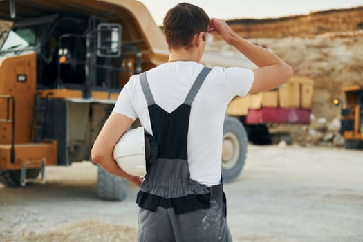 Rear view. Worker in professional uniform is on the borrow pit at daytime photo