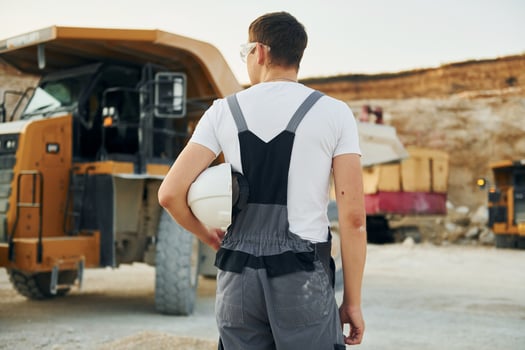 Rear view. Worker in professional uniform is on the borrow pit at daytime photo