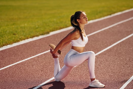 Focused athlete. Young woman in sportive clothes is exercising outdoors photo