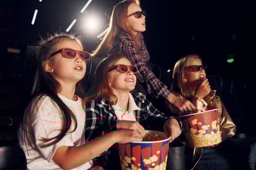 Side view. Group of kids sitting in cinema and watching movie together photo