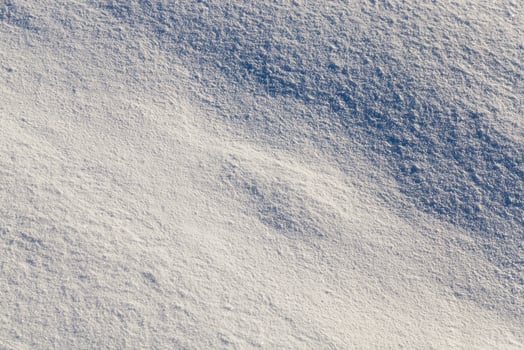 land covered with snow   white snow after snow had fallen and covered the land in the agricultural field. Photo closeup in the winter season, a small depth of field. On visible surface roughness snow